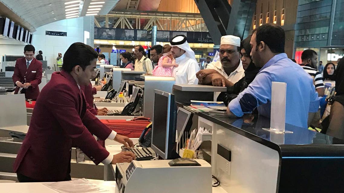 In this Monday, June 12, 2017 photo, Qatari and other nationals queue at the check in counters of the Hamad International Airport in Doha, Qatar. An AP videojournalist recounts her struggle to fly back home to Dubia after a diplomatic dispute with Arab Gulf countries saw Qatar, a hub of global air travel, cut off from local flight routes. (AP Photo/Malak Harb)