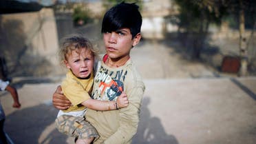 A yazidi boy holds his sister in a playground in Sinjar region. Iraq's Yazidis are marking three years since Islamic State launched what the United Nations said was a genocidal campaign against them, but their ordeal is far from over despite the ouster of the jihadist fighters. (Reuters)