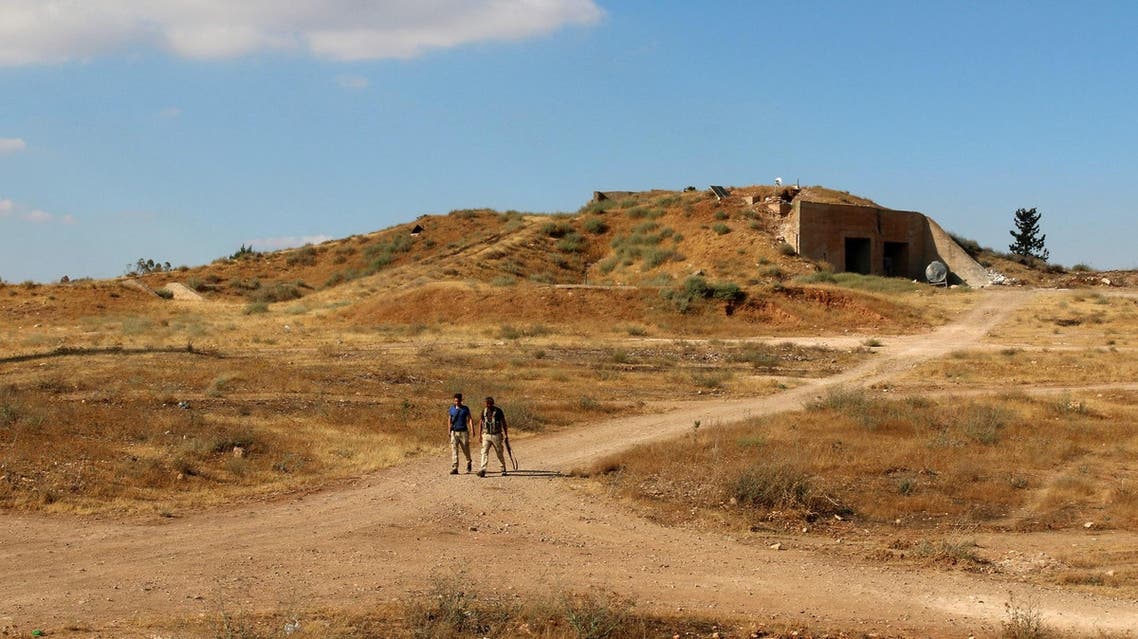 Rebel fighters walk at a rebel held military base southwest of the Deraa city near the Jordan border. (Reuters)