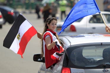 A girl carries a national flag while riding in a car as people gather in Tahrir square to celebrate an extension of the Suez Canal, in Cairo, Egypt, August 6, 2015. (Reuters)