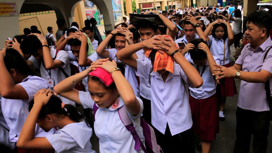 Students use their hands to cover their heads as they evacuate their school premises after an earthquake hit the northern island of Luzon and was felt in the Metro Manila. (Reuters)