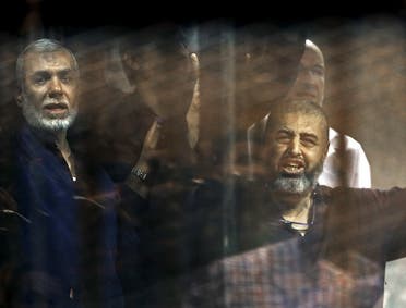 Muslim Brotherhood members gesture behind bars after their verdict at a court on the outskirts of Cairo, Egypt June 16, 2015. (Reuters)