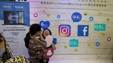 In this Friday, April 28, 2017, photo, a woman reacts near a booth promoting overseas marketing services on Facebook and instagram which are banned in China during an internet conference in Beijing. (AP)