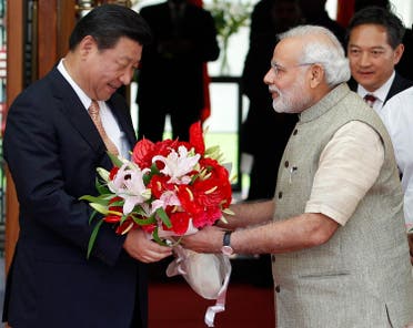 India’s Prime Minister Narendra Modi presents a bouquet to China’s President Xi Jinping (L) before their meeting in the western Indian city of Ahmedabad September 17, 2014. (Reuters)