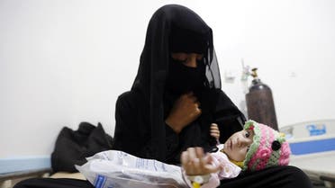Yemeni woman holds her child, who is suspected of being infected with cholera, at a makeshift hospital in the capital Sanaa. (AFP)