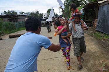 A rescue worker (L) meets residents who were evacuated from their homes after nine days at a village on the outskirts of Marawi on the southern island of Mindanao on May 31, 2017. (AFP)