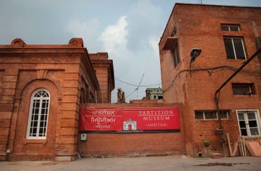 A worker looks on from atop a wall with a banner for the Partition Museum that is set to open later this week in Amritsar. (AP) 