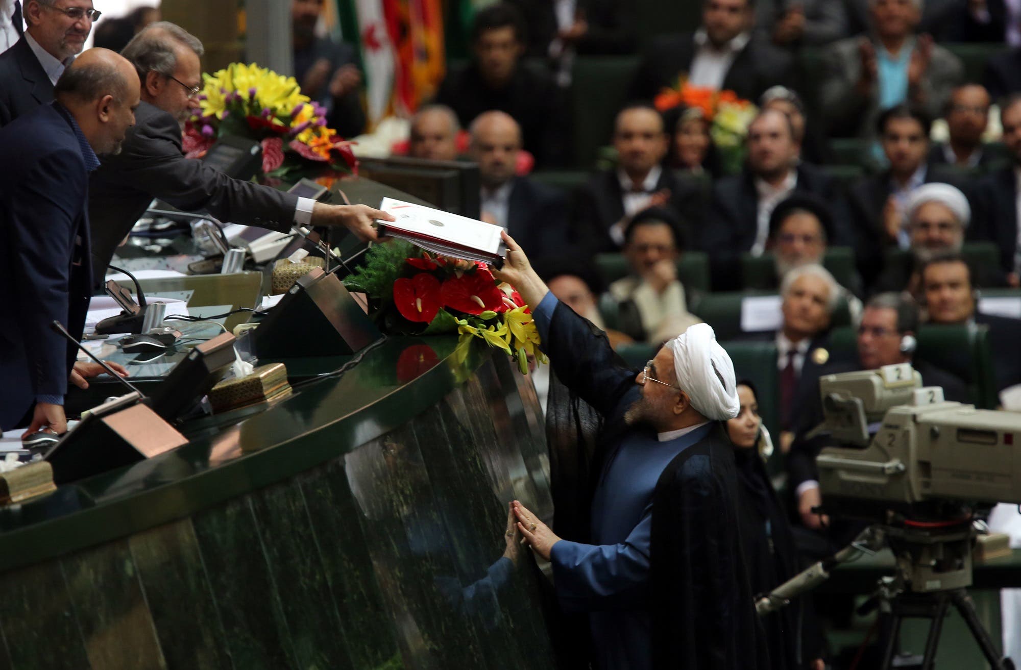 Hasan Rowhani delivering his cabinet list to Parliament Speaker Ali Larijani after he was sworn in before parliament in Tehran on August 4, 2013. (AFP)