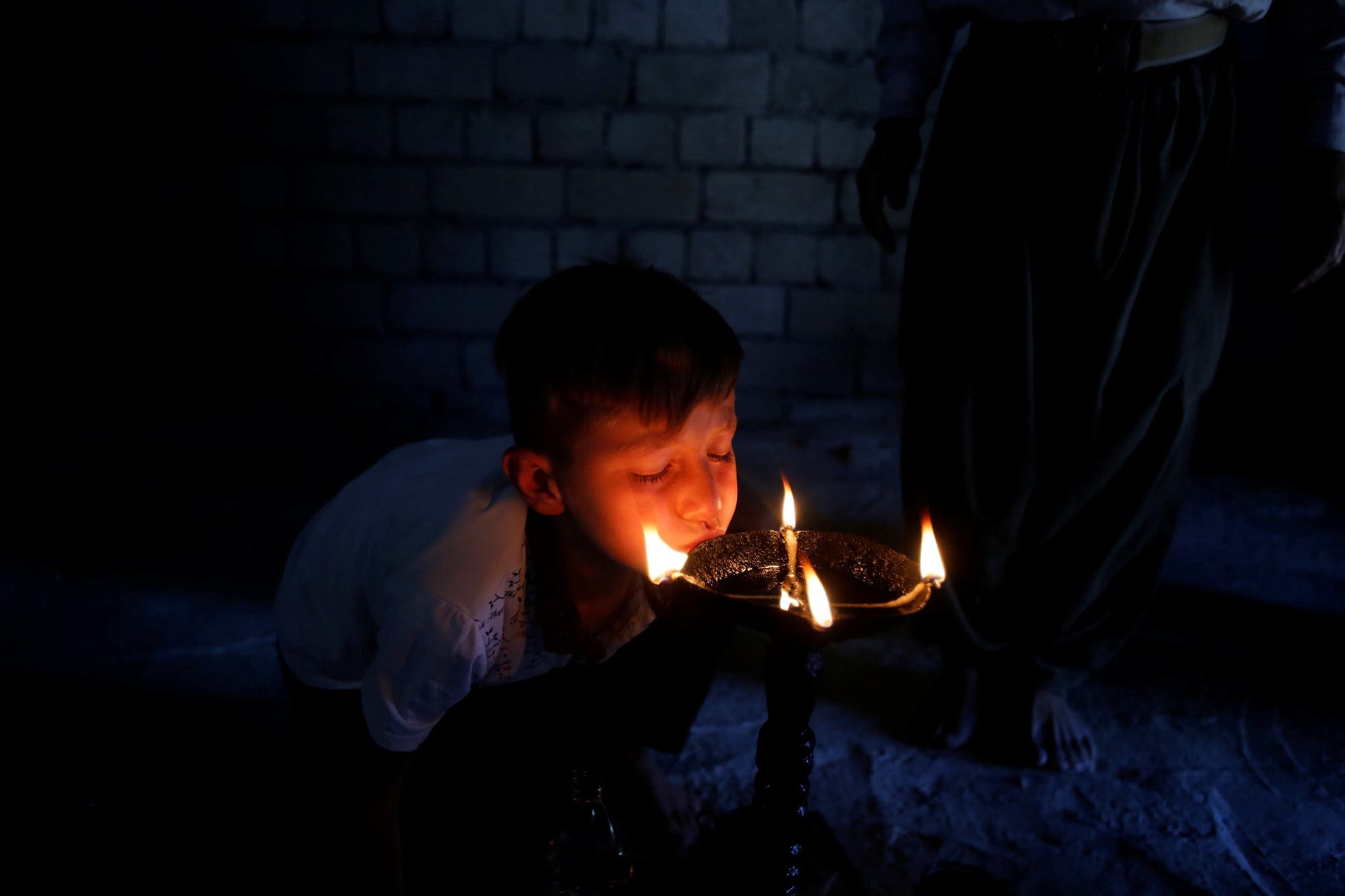 A boy from the minority Yazidi sect, worships at a Yazidi shrine which is being rebuilt after it was destroyed by ISIS, in Bashiqa, a town near Mosul, on August 8, 2017. (Reuters)