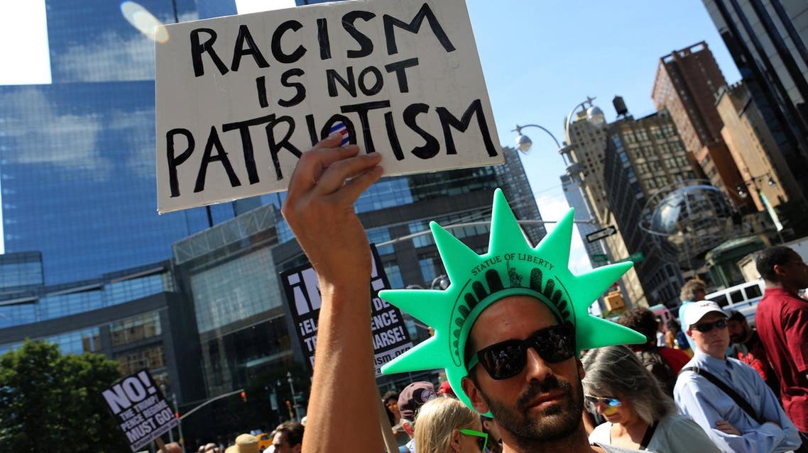A protester holds a sign reading "Racism is not Patriotism" at a march against white nationalism in New York City. (Reuters)