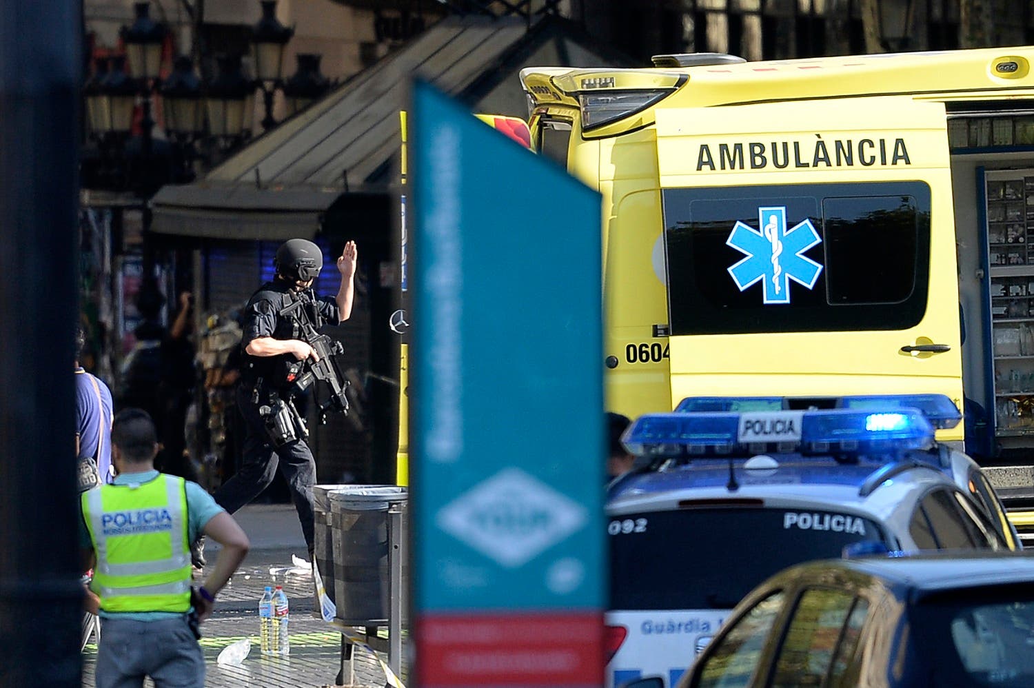 An armed policeman arrives in a cordoned off area after a van ploughed into the crowd, injuring several persons on the Rambla in Barcelona on August 17, 2017. AFP