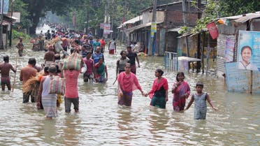 (FILES) This file photo taken on August 17, 2017 shows Indian residents wading through flood waters in Balurghat in West Bengal. Torrential rain across India, Nepal and Bangladesh has killed at least 700 people since August 10, as the annual monsoon swept the north and east of the region. (AFP)
