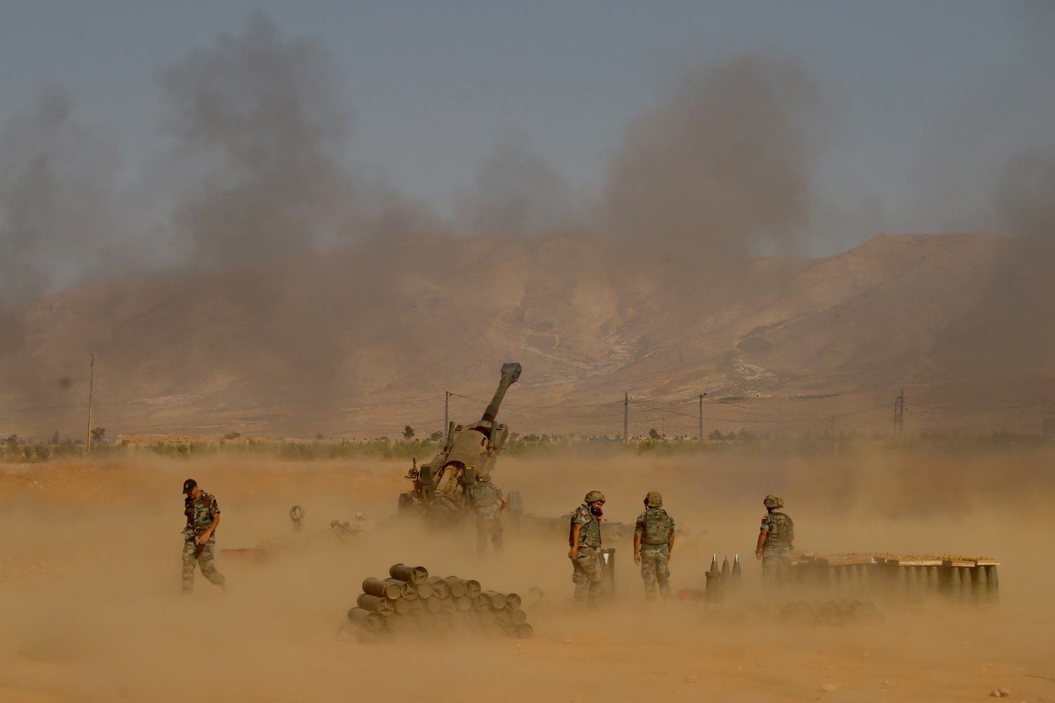 A picture taken on August 17, 2017, during a tour guided by the Lebanese army, shows soldiers firing towards jihadist militants from recently captured positions, in a mountainous area near the town of Ras Baalbek. (AFP)
