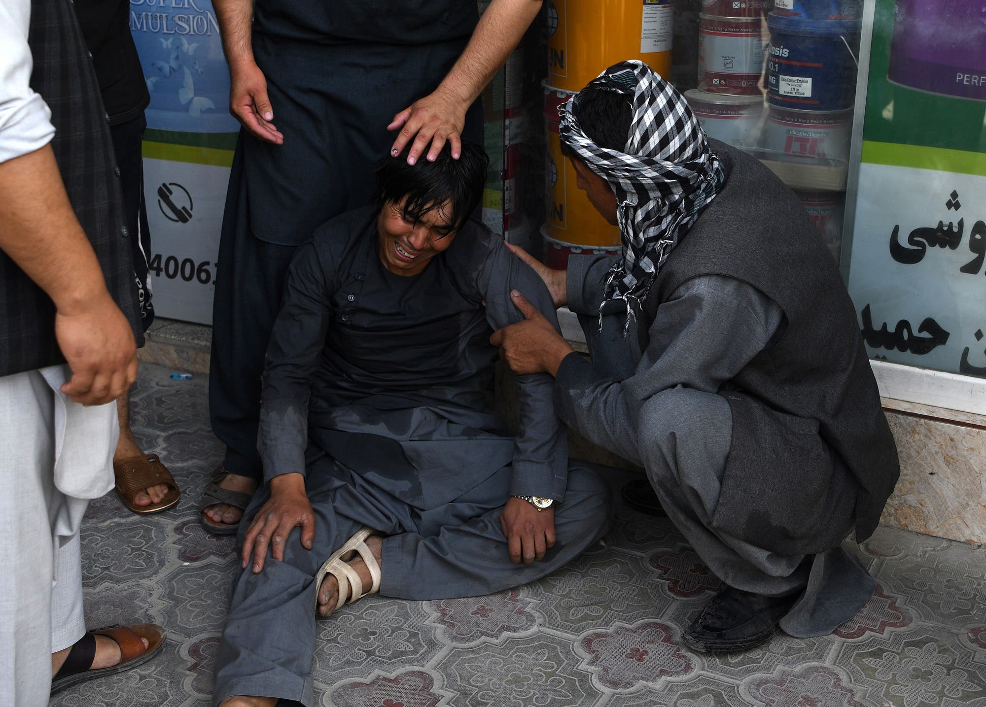 An Afghan worshipper is consoled as he cries near the site of suicide attack that targeted a mosque in Kabul on Friday (AFP)