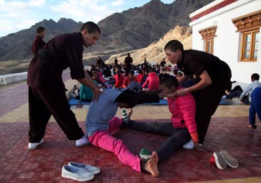 Buddhist nuns help participants stretch during a five-day workshop teaching young women the martial art of Kung Fu, in Hemis region in Ladakh, August 18, 2017. (Reuters)