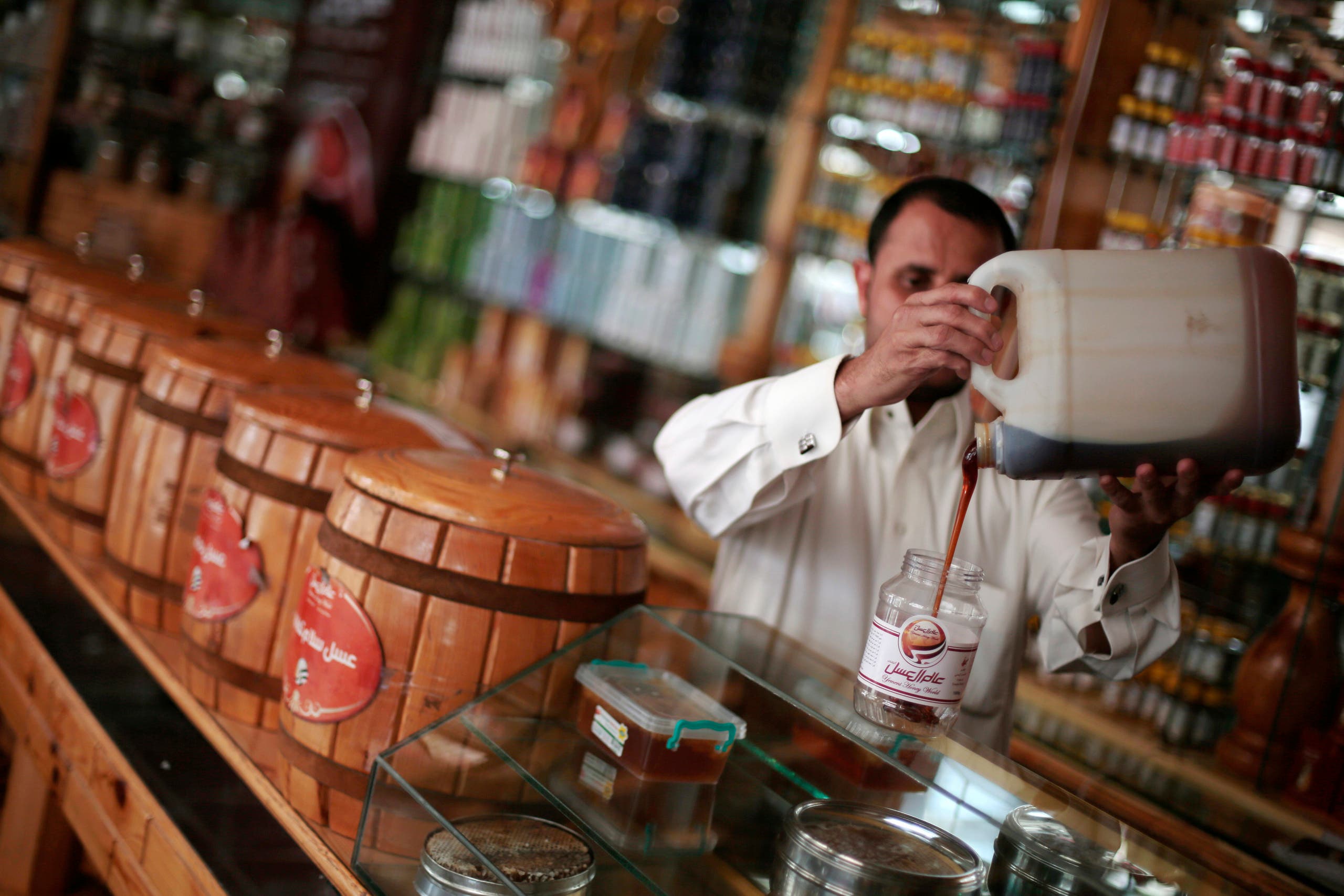 In this Tuesday, Aug. 22, 2017 photo, a Yemeni vendor displays honey for sale in a shop in Sanaa, Yemen. AP