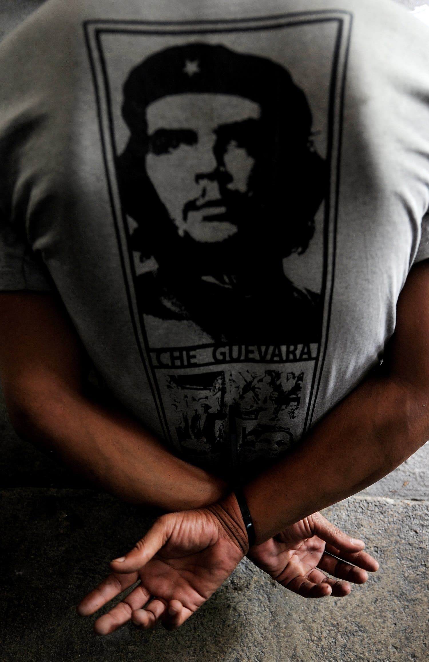 A Red Shirt anti-government protester wearing a t-shirt with a piture of late revolutionary leader Che Guevera is detained by soldiers inside their camp in Bangkok on May 19, 2010. (AFP)