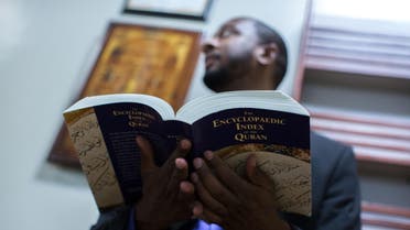 Rashad Abdul-Rahman holds a book at the Atlanta Masjid of Al Islam mosque, Sunday, Aug. 30, 2015, in Atlanta. Members of the mosque gathered to celebrate a group of pilgrims who will make the annual Hajj pilgrimage to the holy city of Mecca. (AP Photo/Branden Camp)