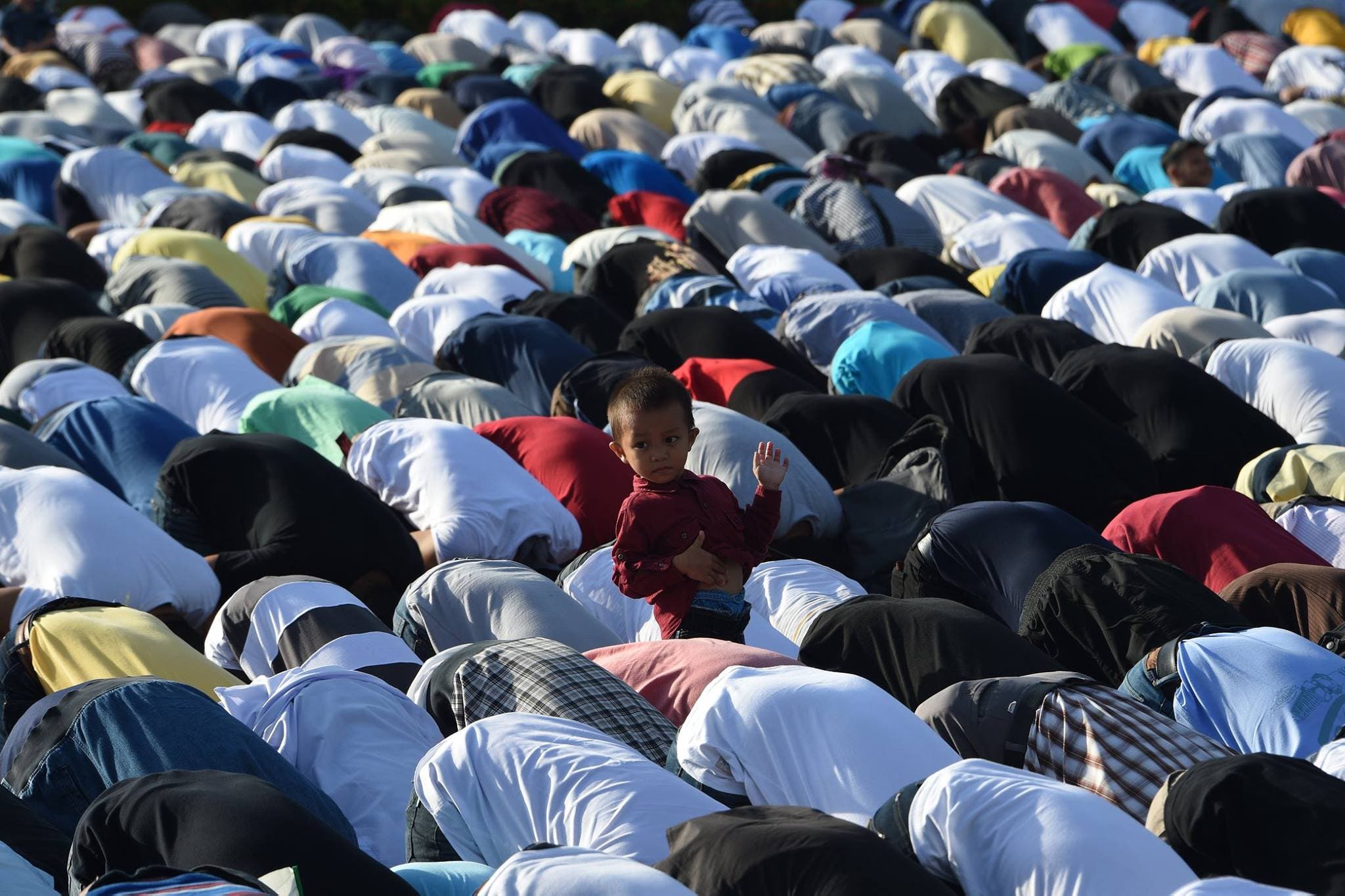 A boy looks on as Filipino Muslims attend Eid al-Adha prayers at a park in Manila on September 1, 2017. (AFP)