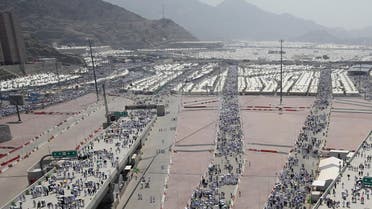 Muslim pilgrims, some holding umbrellas to protect themselves from the sun, head to take part in the symbolic stoning of the devil at the Jamarat Bridge in Mina, near Mecca. (AFP)