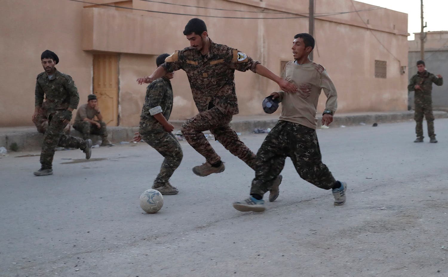Kurdish fighters from the People’s Protection Units (YPG) play football on a street in Raqqa, Syria June 26, 2017. (Reuters)