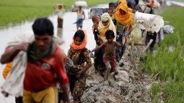 Rohingya refugees walk on the muddy path after crossing the Bangladesh-Myanmar border in Teknaf, Bangladesh, September 3, 2017. (Reuters)
