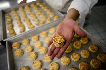 Chef Yip Wing-wah displays his freshly oven-baked signature “spring moon mini egg custard mooncakes”. (AFP)