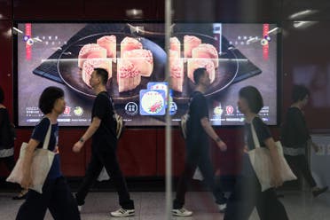 In this picture taken on September 2, 2017, people walk past an advertisement for mooncakes in a train station in Hong Kong. (AFP)