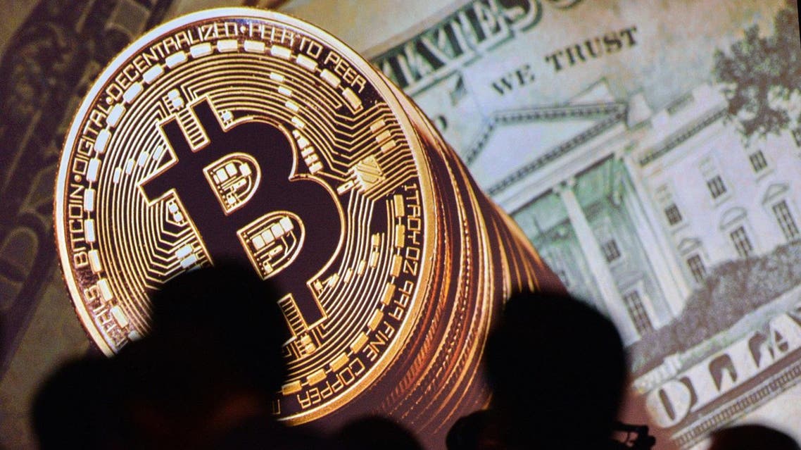 An image of Bitcoin and US currencies is displayed on a screen as delegates listen to a panel of speakers during the Interpol World Congress in Singapore on July 4, 2017. The three-day conference on fostering innovation for future security challenges is taking place from July 4 to 6.