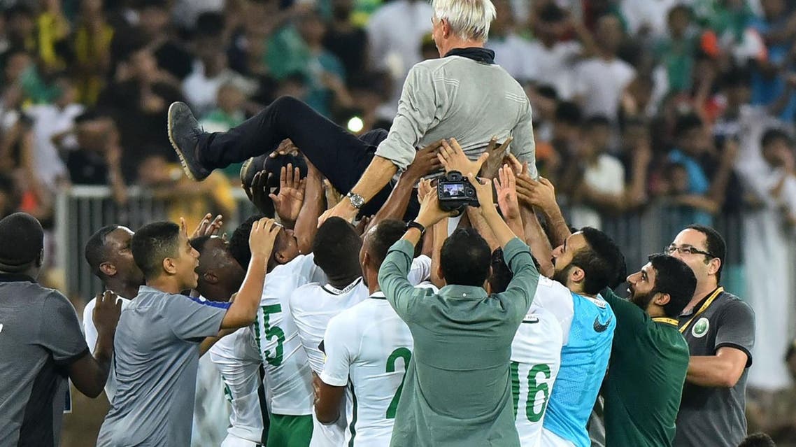 Members of Saudi Arabia's football team carry head coach Bert van Marwijk as they celebrate at the end of the FIFA World Cup 2018 qualification football match between Saudi and Japan at King Abdullah bin Abdulaziz Stadium in Jeddah on September 5, 2017. (AFP)