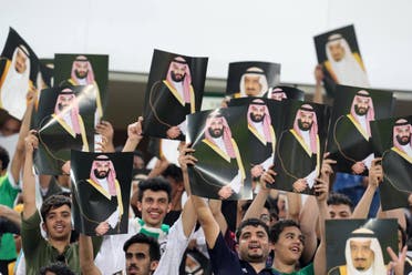 Saudi Arabia fans cheer as they hold up pictures of Saudi King Salman and Saudi Crown Prince and Minister of Defense Mohammed bin Salman. (AP)