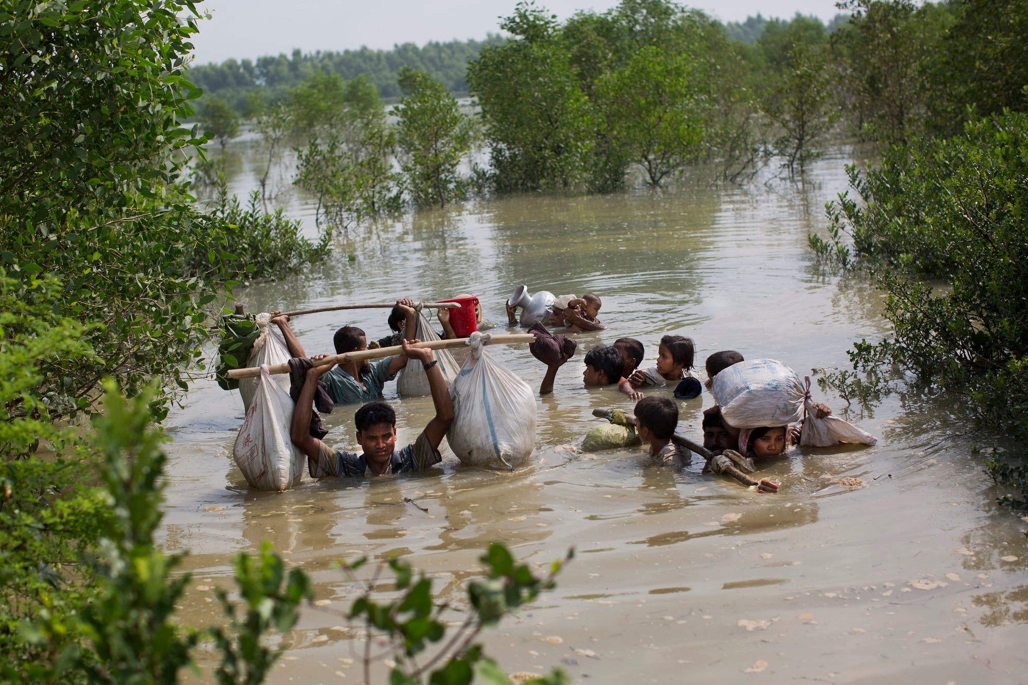 A Rohingya family reaches the Bangladesh border after crossing a creek of the Naf river on the border with Myanmmar, in Cox’s Bazar’s Teknaf area, on Sept. 5, 2017. (AP)
