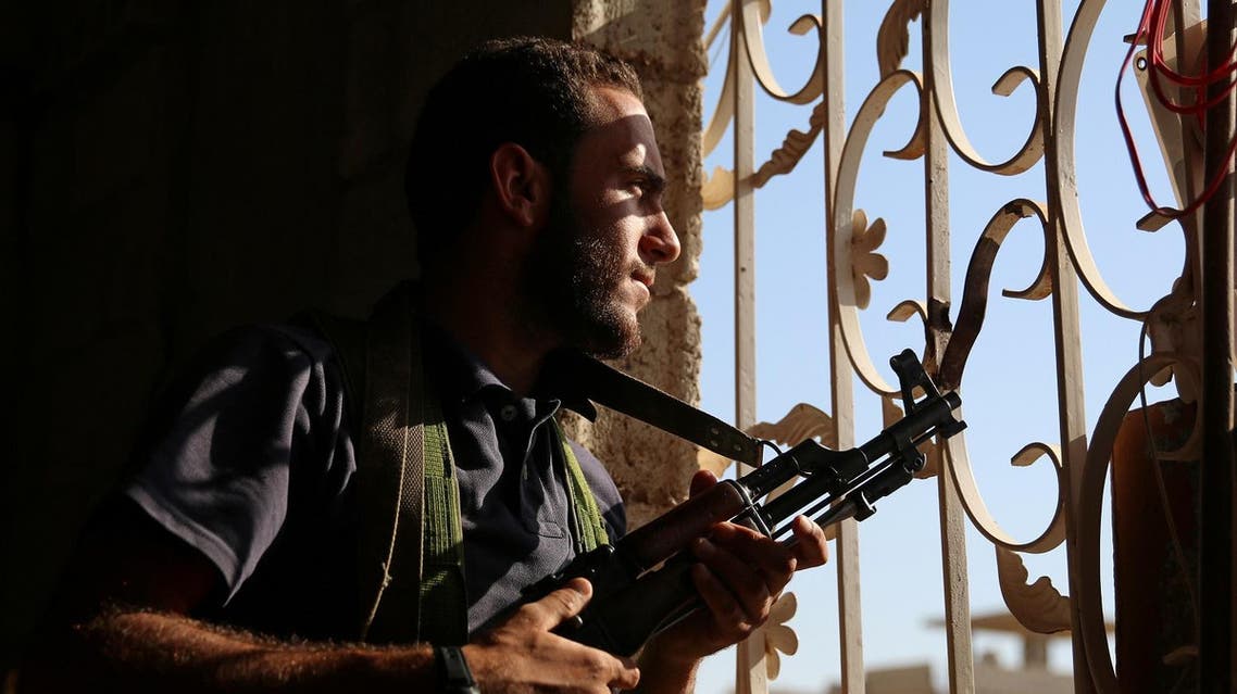 A Free Syrian Army fighter looks out through a window in rebel-held Al-Yadudah village, in Deraa Governorate, Syria, July 19, 2017. REUTERS/Alaa Al-Faqir