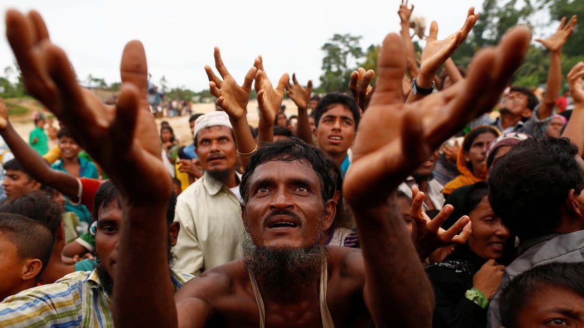 Rohingya refugees stretch their hands to receive food distributed by local organizations in Kutupalong. (Reuters)