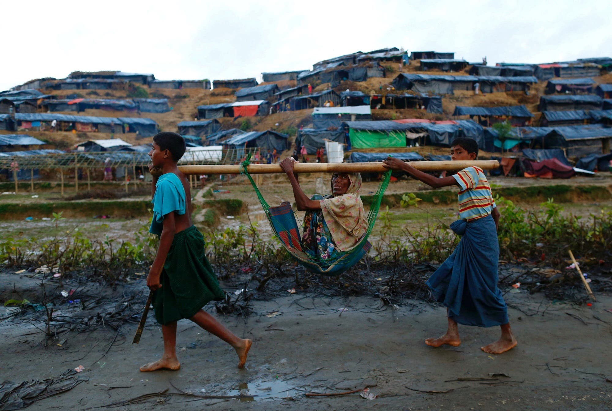 Rohingya refugee children carry an old woman in a sling near Balukhali makeshift refugee camp in Cox’s Bazar, Bangladesh, September 13, 2017. (Reuters)