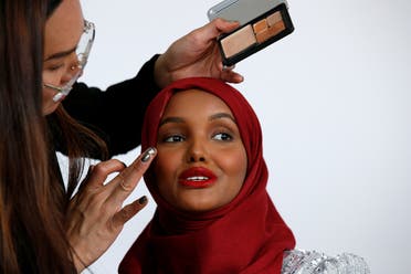 Fashion model and former refugee Halima Aden, who is breaking boundaries as the first hijab wearing model gracing magazine covers and walking in high profile runway shows has her makeup applied during a shoot at a studio in New York. (Reuters)