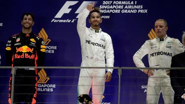 Mercedes’ Lewis Hamilton celebrates winning the race on the podium with Red Bull’s Daniel Ricciardo and Mercedes’ Valtteri Bottas. (Reuters)