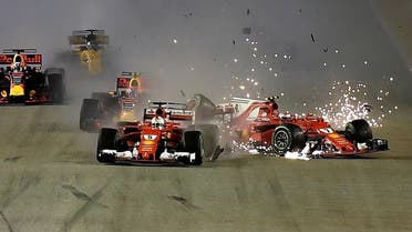 The car of Ferrari's Finnish driver Kimi Raikkonen (R) is seen beside Ferrari's German driver Sebastian Vettel (C) after a crash during the Formula One Singapore Grand Prix in Singapore on September 17, 2017.  MANAN VATSYAYANA / AFP