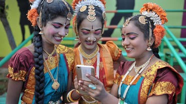 Indian girls look at a mobile phone prior to taking part during Independence Day celebrations in Secunderabad, the twin city of Hyderabad, on August 15, 2017. (AFP)