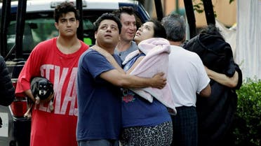 People stand together on a street after a tremor was felt in Mexico City. (Reuters)