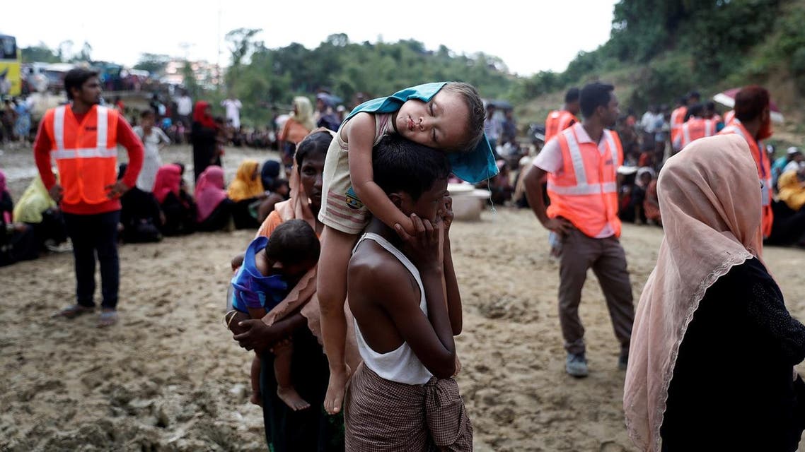 A Rohingya refugee child sleeps as people queue for aid in a camp in Cox's Bazar, Bangladesh, September 22, 2017. (Reuters)