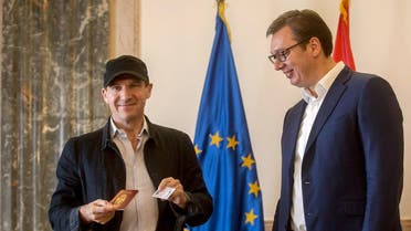 British actor Ralph Fiennes (L) poses after receiving a Serbian passport and ID card from Serbia's President Aleksandar Vucic in Belgrade. (AFP)
