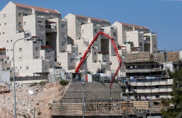 Construction workers build new houses in the Israeli settlment of Kiryat Arba, east the West Bank town of Hebron, August 24, 2017. (AFP)