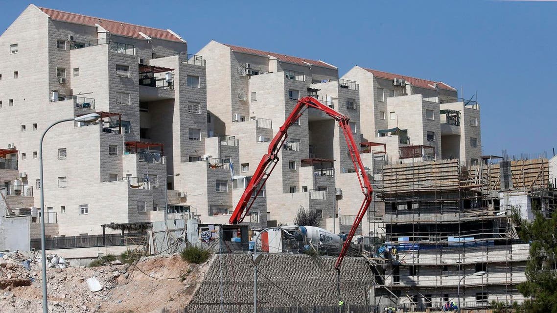 Construction workers build new houses in the Israeli settlment of Kiryat Arba, east the West Bank town of Hebron, August 24, 2017. (AFP)