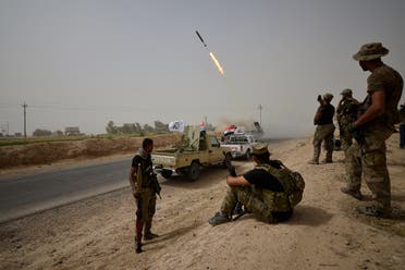 Shi'ite Popular Mobilization Units (PMU) with Iraqi rapid response members fire a missile against ISIS on the outskirts of Shirqat. (Reuters)