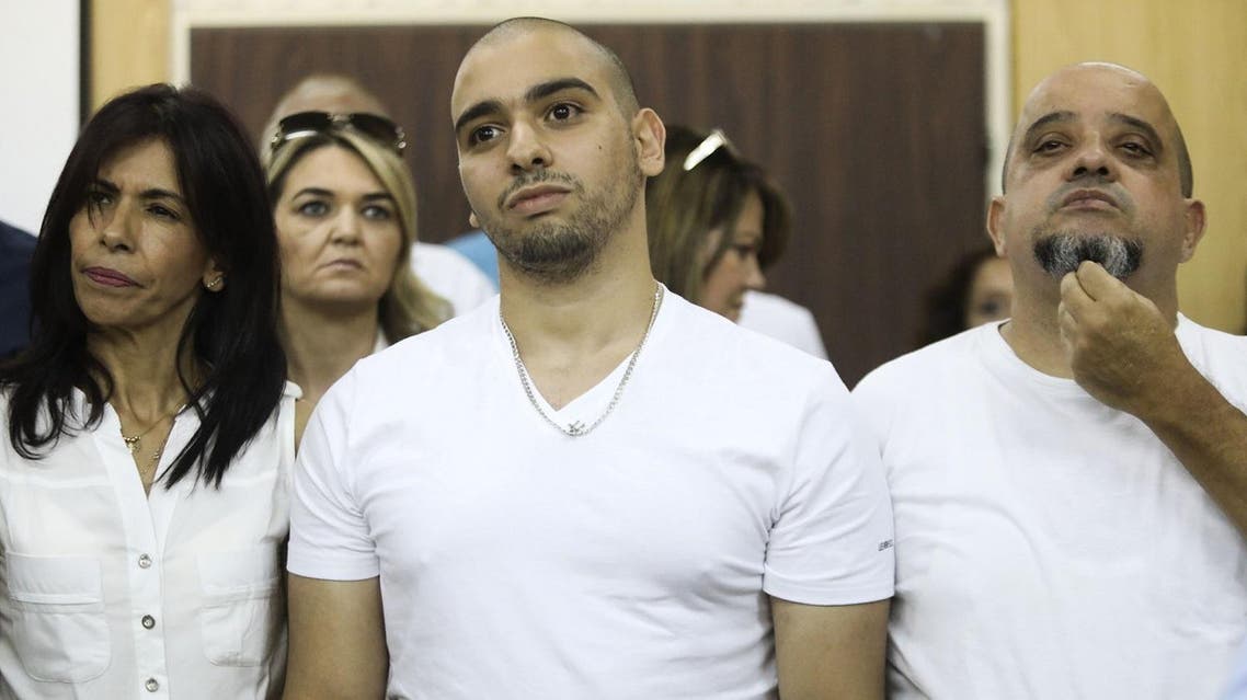 (FILES) This file photo taken on July 30, 2017 shows Israeli soldier Elor Azaria (C), who shot dead a wounded Palestinian assailant in March 2016, standing next to his mother Oshra (L) and father Charlie during a hearing at a military court in Tel Aviv. Israel's military chief of staff on September 27, 2017, reduced the sentence of Azaria convicted of manslaughter for shooting dead a prone Palestinian assailant by four months, with the case having deeply divided the country. (AFP)