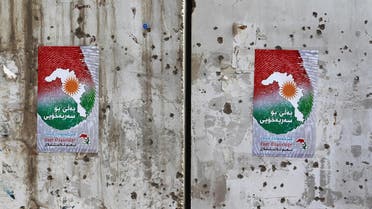 Posters encouraging people to vote in the upcoming independence referendum for the Kurdistan region are seen on a bullet-riddled wall in the Iraqi city of Kirkuk on September 24, 2017. Iraqi Kurds are preparing to vote in a referendum set for September 25 on independence for their autonomous northern region, despite warnings within the country and from neighbours Iran and Turkey. AFP