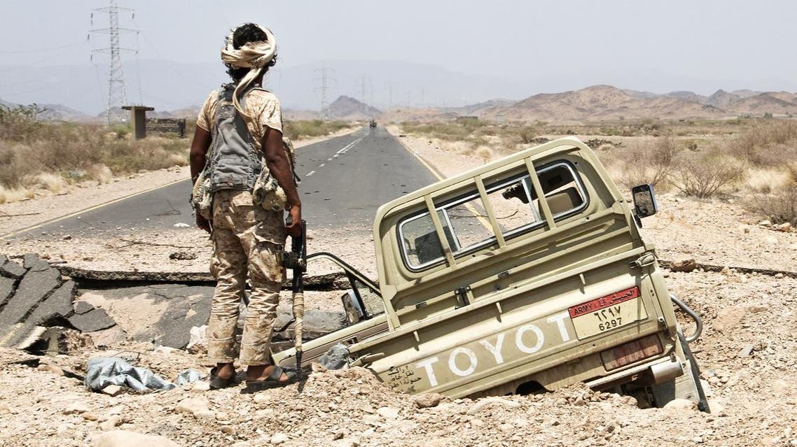 A Yemeni fighter loyal to the Saudi-backed Yemeni president stands next to an army Toyota pickup truck as it lies in hole on the road leading to Khaled Ibn Al-Walid base, 30 kilometres (20 miles) east of the government-held Red Sea port town of Mokha, on April 15, 2017. (AFP)