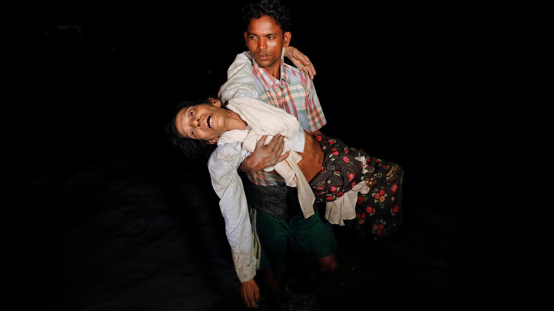 Nobi Hossain wades through the water carrying his elderly relative Sona Banu under the cover of darkness from Myanmar to Cox’s Bazar in Bangladesh, on September 27, 2017. (Reuters)