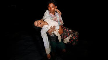 Nobi Hossain wades through the water carrying his elderly relative Sona Banu under the cover of darkness from Myanmar to Cox’s Bazar in Bangladesh, on September 27, 2017. (Reuters)